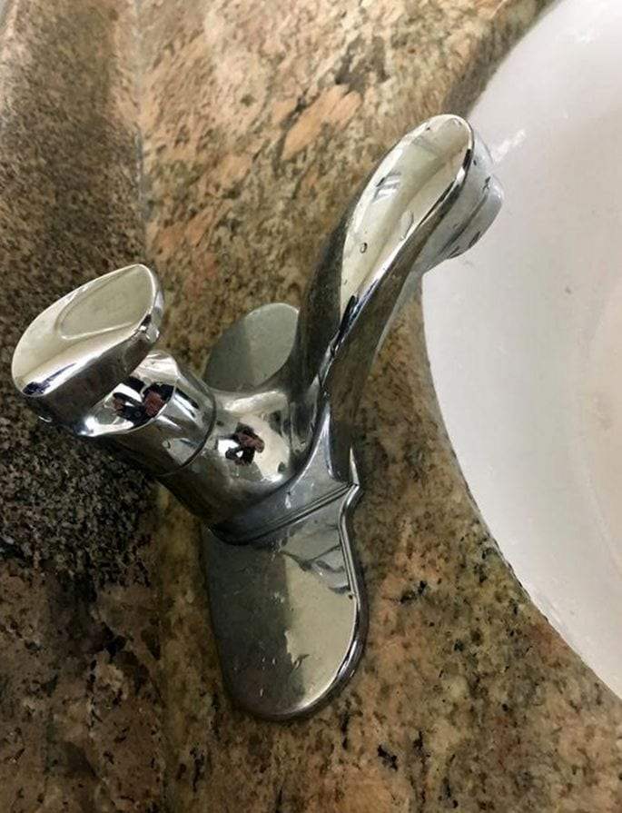 Chrome single-lever faucet mounted on a granite vanity beside the basin