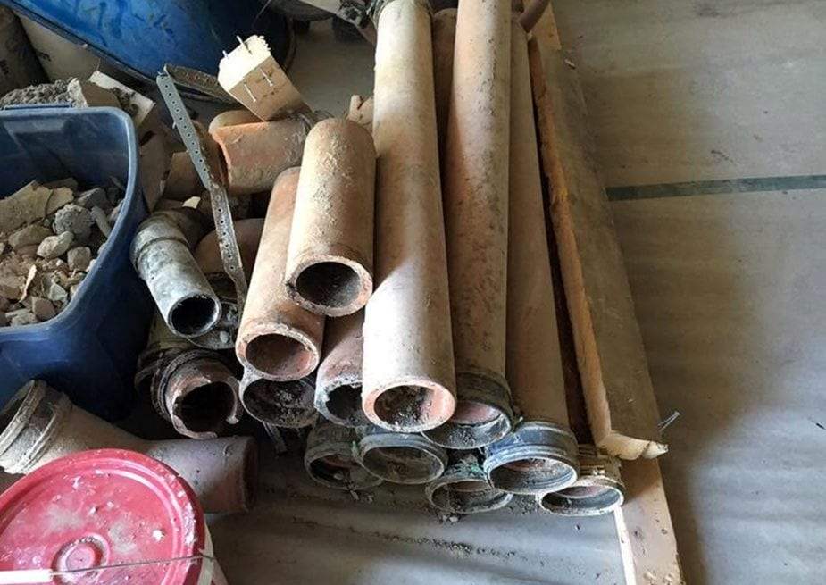 Pile of old galvanized and cast iron pipe sections removed from a house during repiping