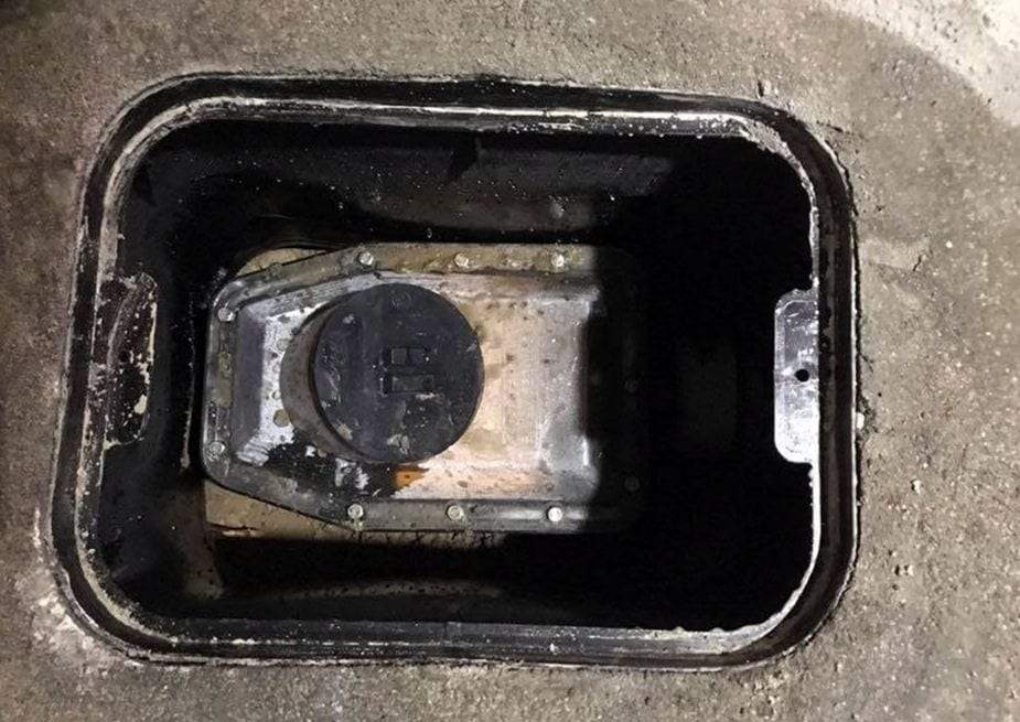Water meter and its fittings inside a meter pit, seen from above