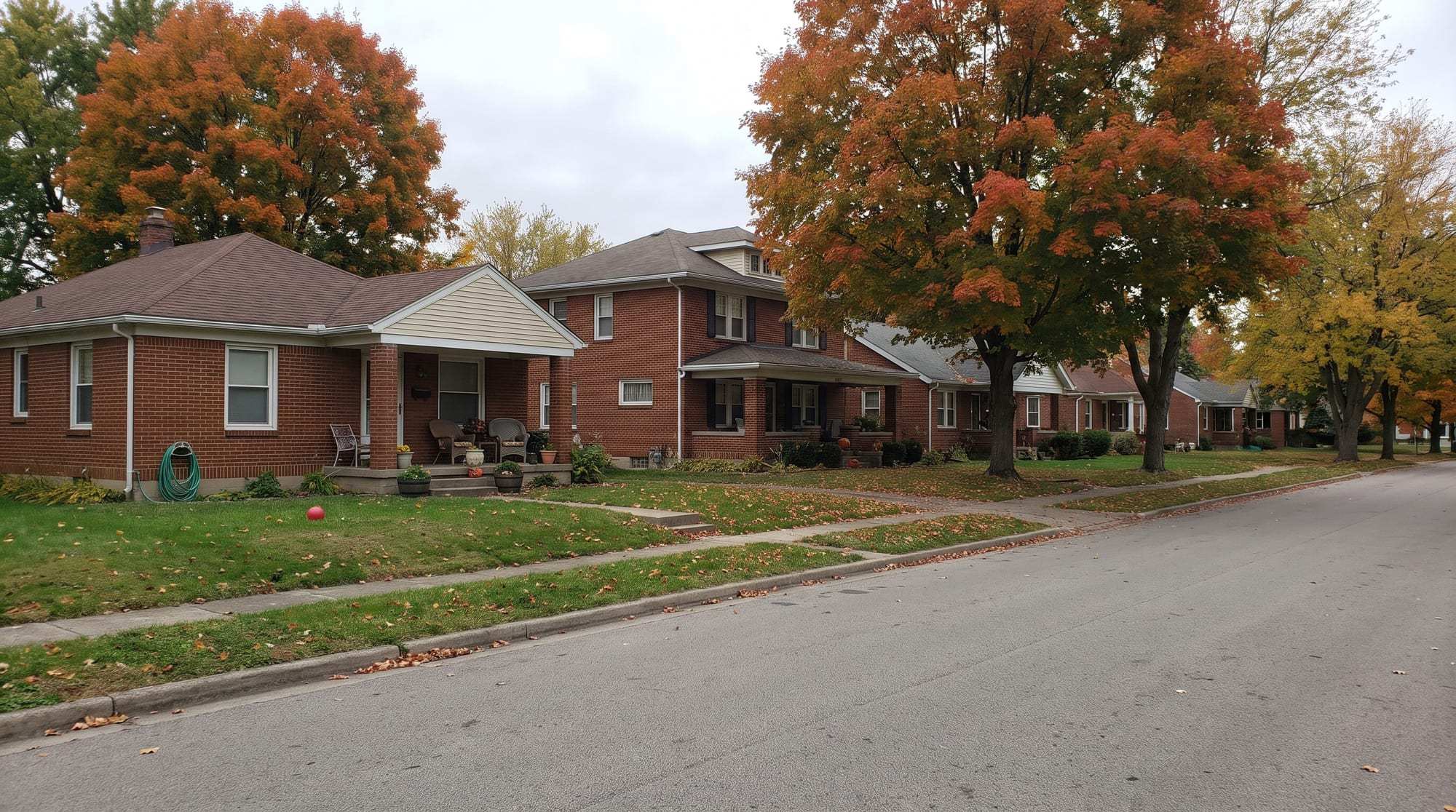 Quiet residential street of brick houses under maples in autumn color